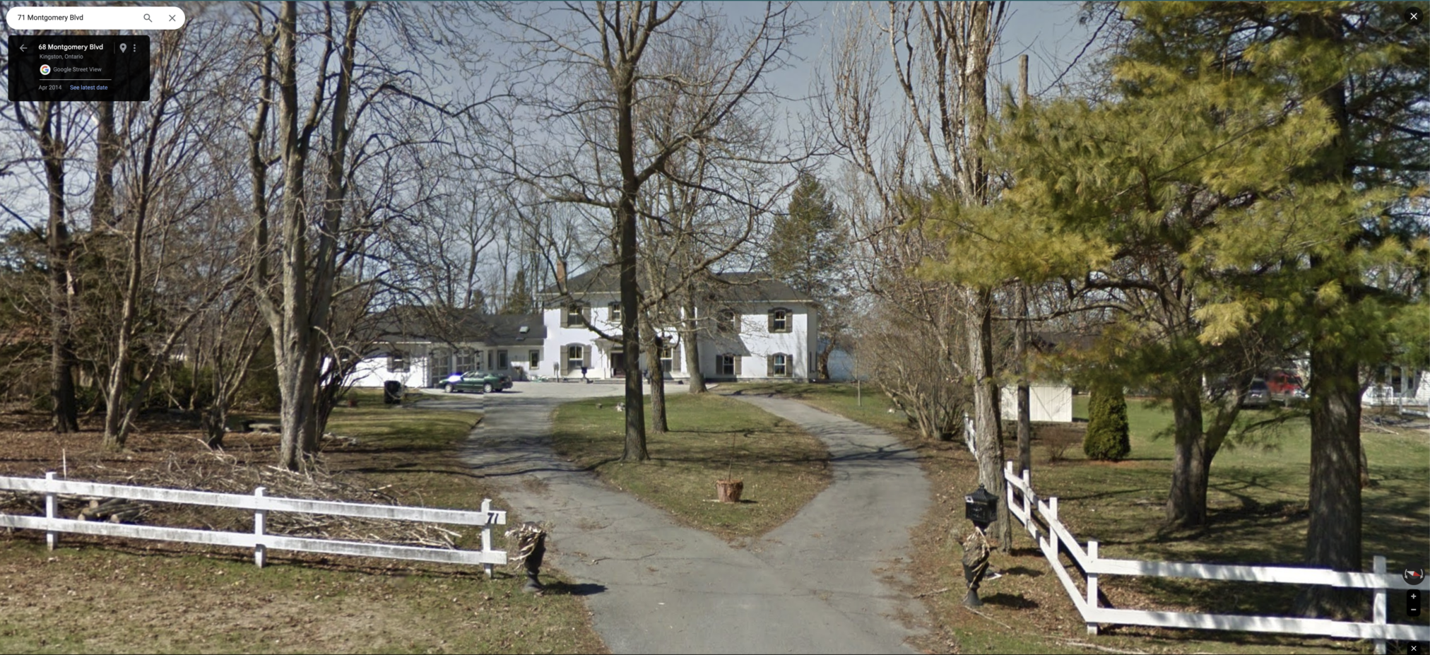 A grand old rural house with white siding, many windows all with shutters