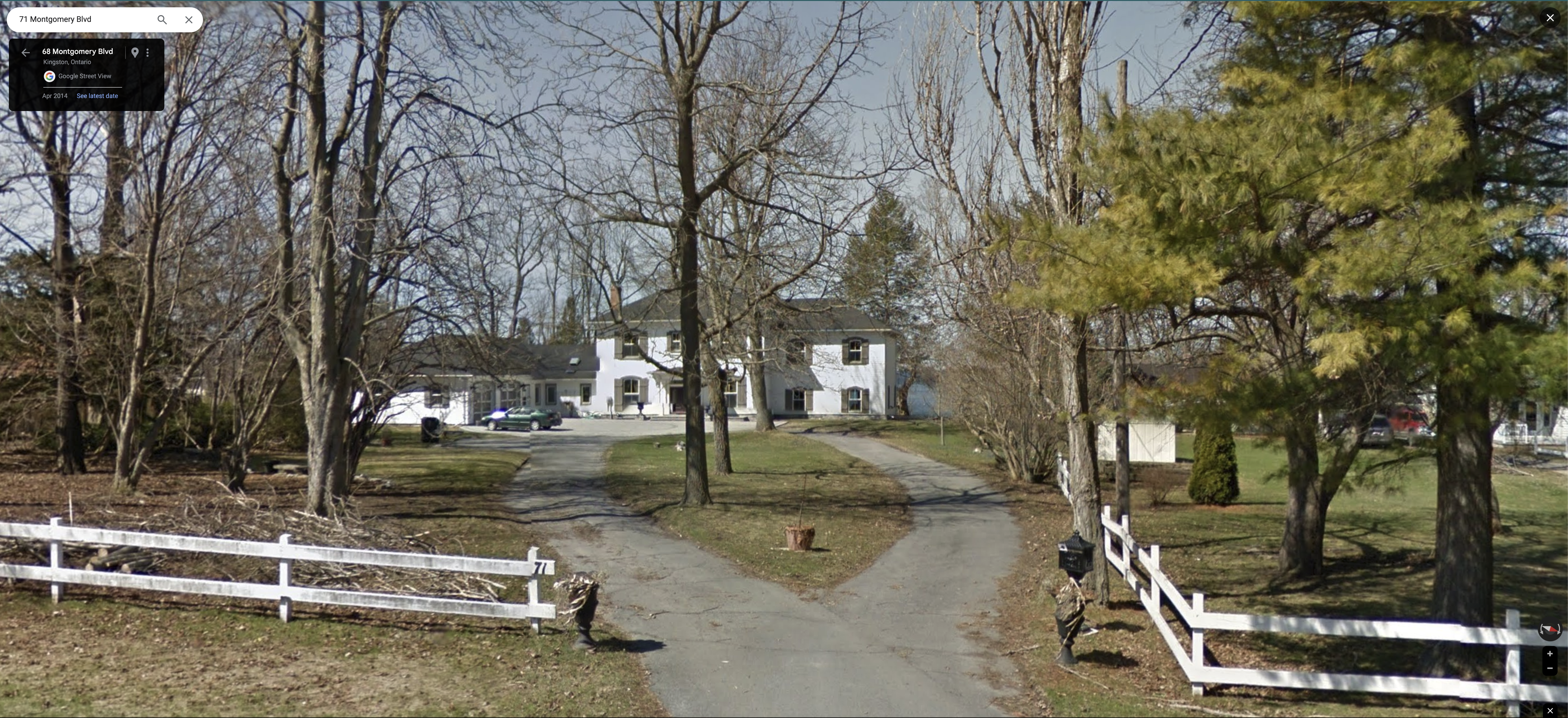 A grand old rural house with white siding, many windows all with shutters